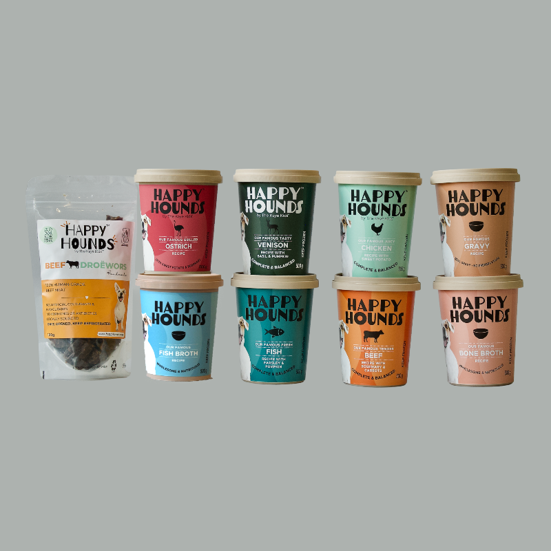 Tubs of Happy Hounds food and toppers against a grey background. 